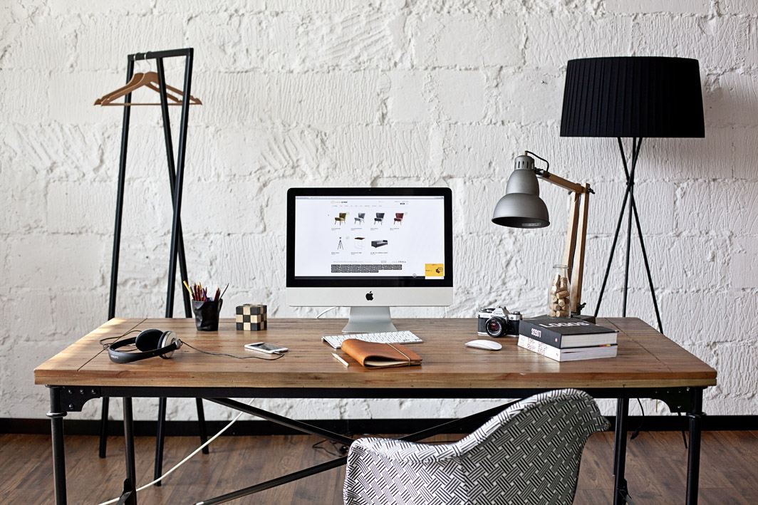 Designer workspace with laptop and sketches